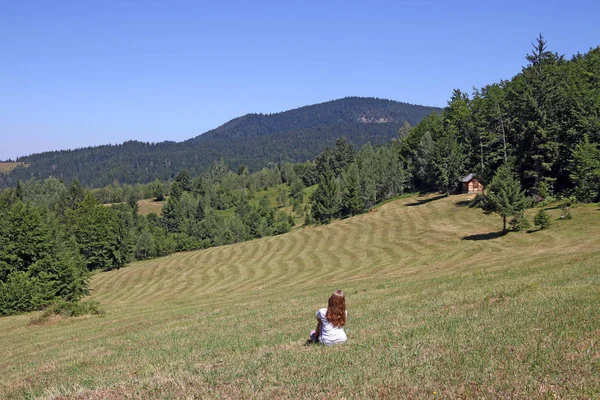 Little girl is sitting in the meadow Tara mountain — Stock Photo, Image