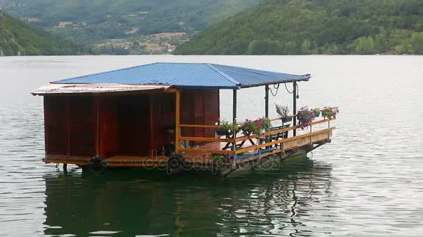 Wooden house floating on river — Stock Video