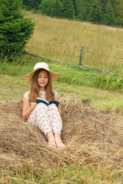Petite fille lit un livre dans la nature — Photo