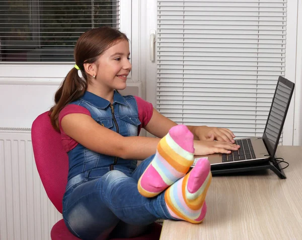 Feliz niña jugando portátil en casa —  Fotos de Stock