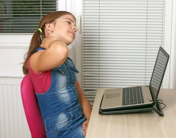 Menina tem dor no pescoço ao usar um laptop — Fotografia de Stock
