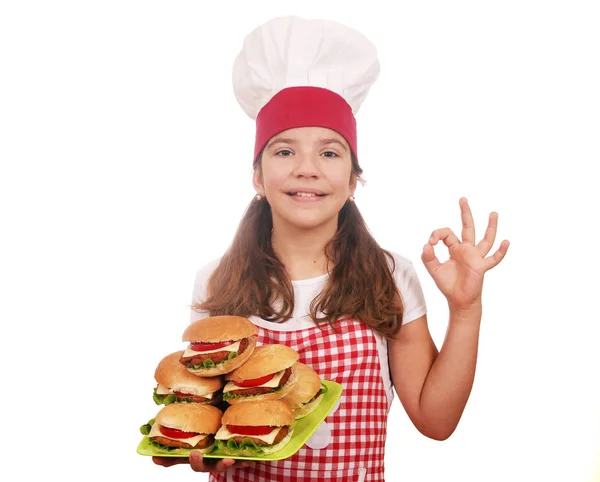 Happy little girl cook with hamburgers and ok hand sign — Stock Photo, Image