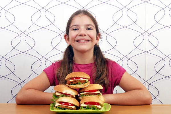 Menina feliz com hambúrgueres fast food — Fotografia de Stock