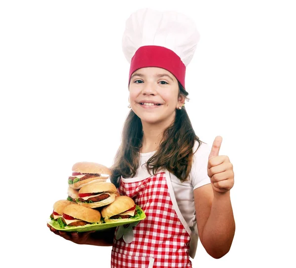 Felice bambina cuoca con hamburger e pollice in su — Foto Stock