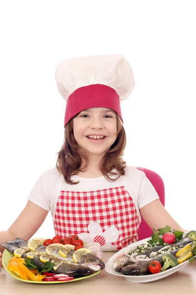 Menina feliz cozinhar com truta no prato — Fotografia de Stock