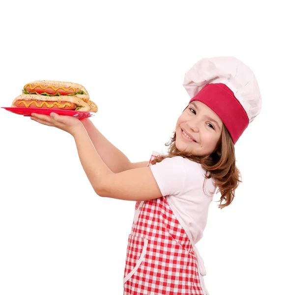 Щаслива маленька дівчинка готує з хот-догами фаст-фуд — стокове фото