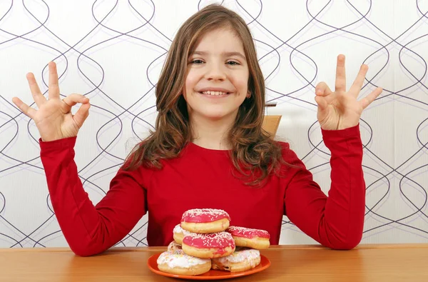 Ευτυχισμένο κοριτσάκι με γλυκό donuts και ok χέρια σημάδια — Φωτογραφία Αρχείου