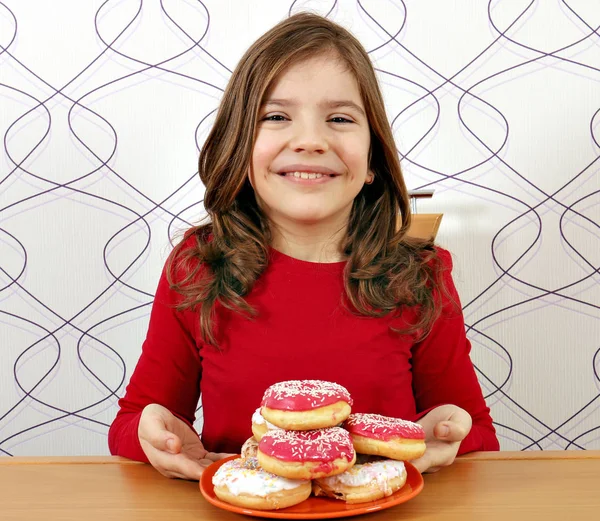 Happy little girl with sweet donuts — Stock Photo, Image