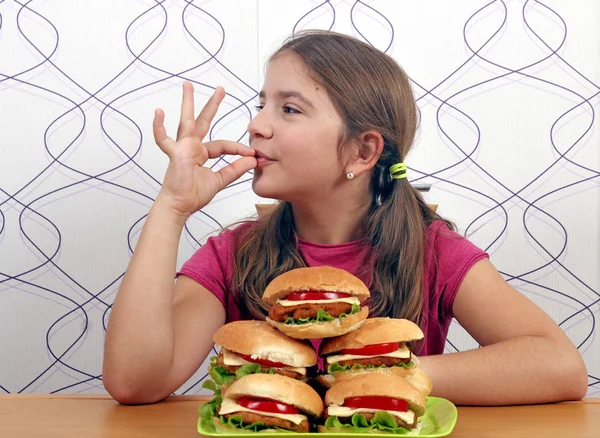 Glückliches kleines Mädchen mit Hamburgern und ok Handzeichen — Stockfoto