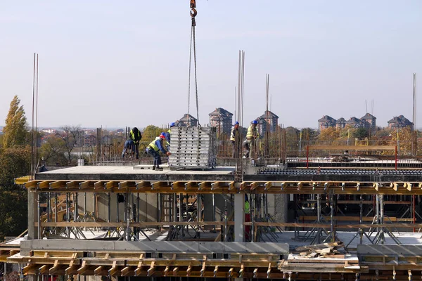 Obra con trabajadores en el tejado del nuevo edificio — Foto de Stock