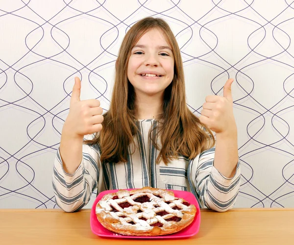 Menina feliz com torta de cereja e polegares para cima — Fotografia de Stock