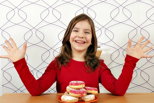 Щаслива маленька дівчинка з солодкими пончиками — стокове фото