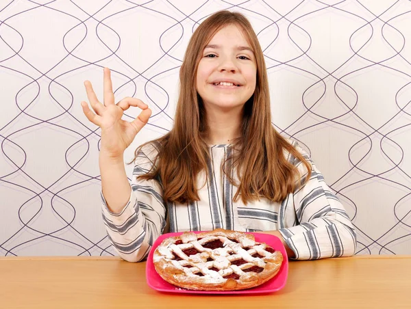 Šťastná holčička s třešňový koláč a značka ok ruky — Stock fotografie