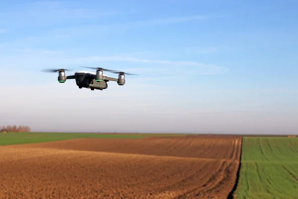 Der Drohnen-Quad-Copter fliegt über das gepflügte Feld — Stockfoto