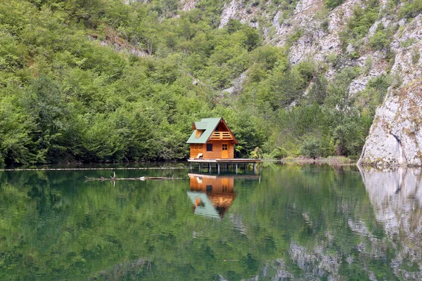 Wooden cottage on green river — Stock Photo, Image