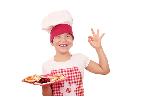 Malé radostné holčičky vařit s ok ruce znamení a sladké palačinky — Stock fotografie