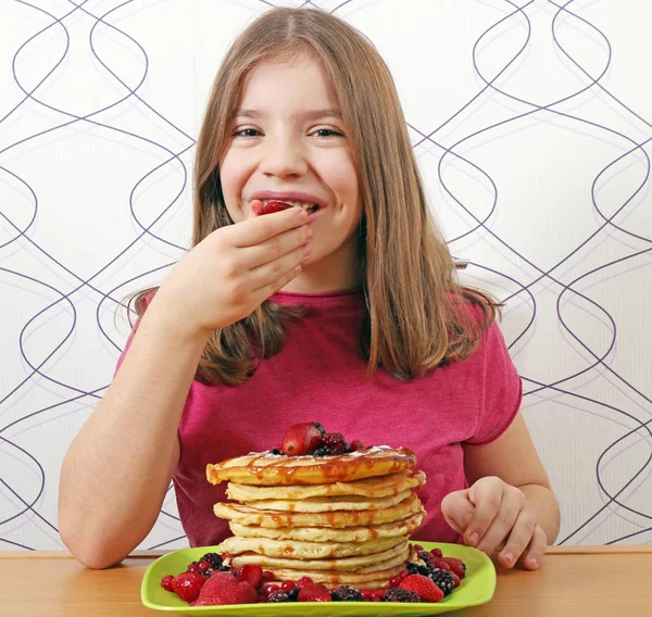 Hungry little girl eat sweet pancakes — Stock Photo, Image