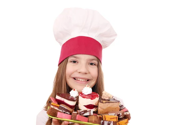 Gelukkig klein meisje koken met gebak op plaat — Stockfoto