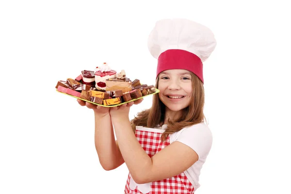 愉快的小女孩烹调与甜蛋糕甜点在板材 — 图库照片