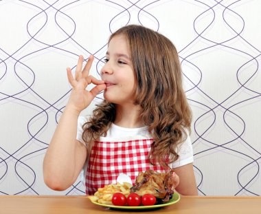 Kavrulmuş Tavuk kanadı ve ok el işareti ile mutlu küçük kız