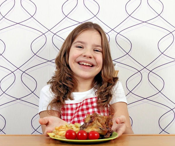 Felice bambina con ali di pollo arrosto sul piatto — Foto Stock