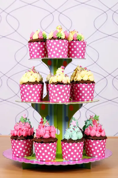 Postre dulce colorido de las magdalenas en la tabla — Foto de Stock