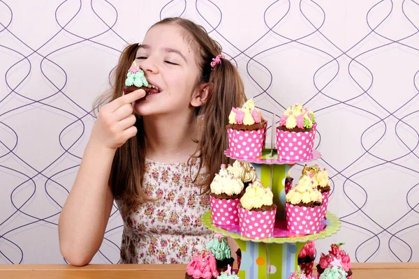 Menina come doce muffin — Fotografia de Stock