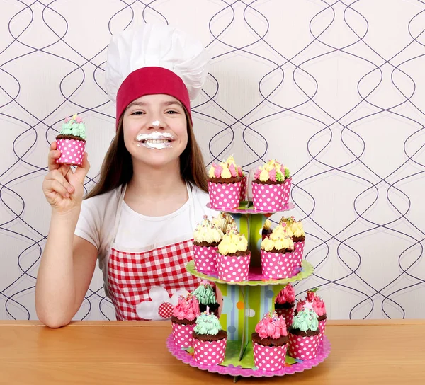 Счастливая маленькая девочка готовить с besmear лицо и кексы — стоковое фото