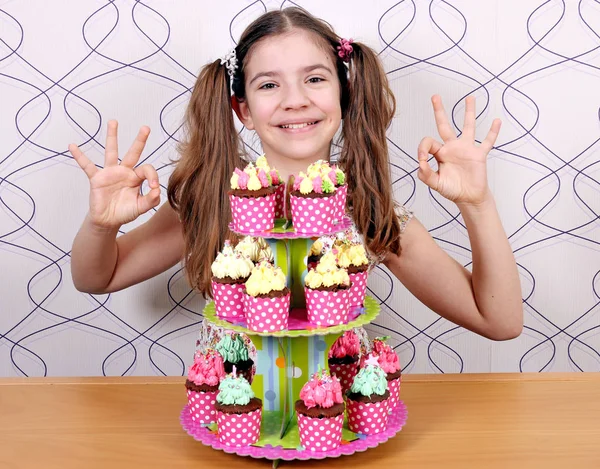 Щаслива маленька дівчинка з кексами та значком для рук — стокове фото