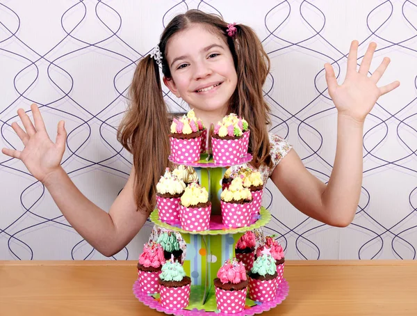 Щаслива маленька дівчинка з солодкими кексами і руками вгору — стокове фото