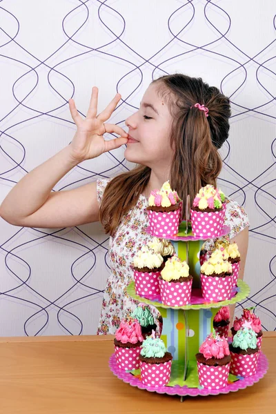 Little girl with muffins and ok hand sign — Stock Photo, Image