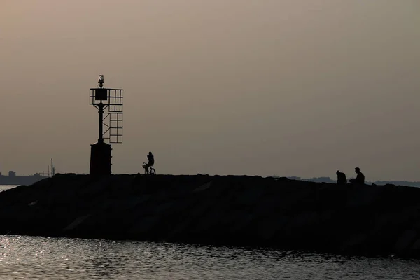 Crepuscolo in mare e sagome umane stagione estiva — Foto Stock