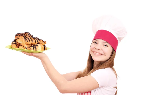 Felice bambina cuoca e gustosa croissant al cioccolato su pla — Foto Stock