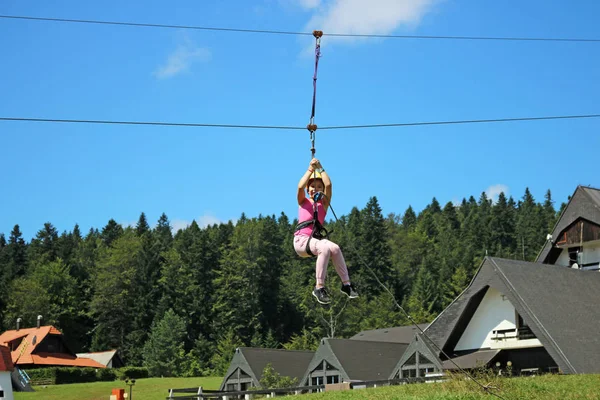 Petite fille glissant sur une tyrolienne extrême parc — Photo