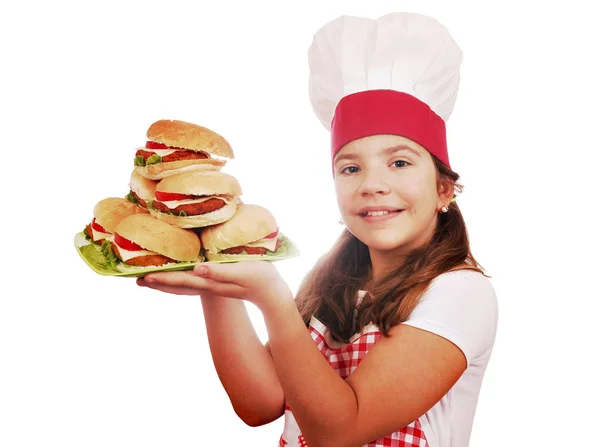 Happy little girl cook with hamburgers on plate — Stock Photo, Image