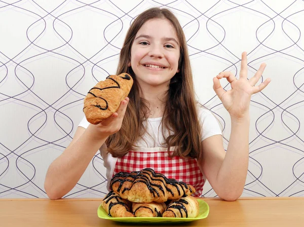 快乐的小女孩与牛角面包和 ok 手牌 — 图库照片