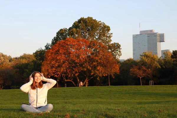 Gelukkig tiener meisje luistert naar muziek van haar smartphone in park — Stockfoto