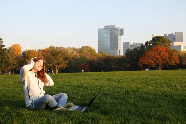 Šťastný dospívající dívka je poslech hudby na notebooku a těší — Stock fotografie