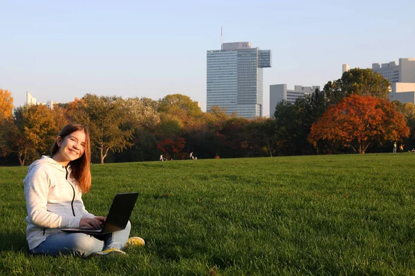 Dospívající dívka s notebookem v parku slunečný podzimní den — Stock fotografie