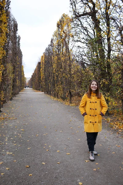 Lány sárga kabátban a parkban Augarten Vienna — Stock Fotó