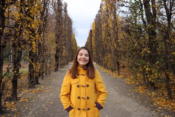 Happy girl in a yellow coat portrait Augarten Vienna — Stock Photo, Image