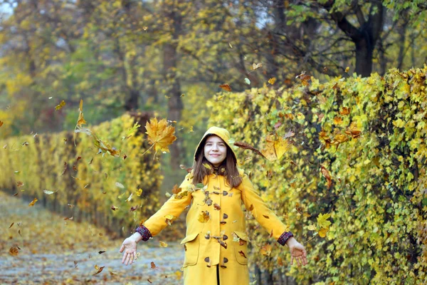 Hojas de otoño caen alrededor de la chica en el parque — Foto de Stock