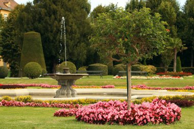 beautiful garden with flowers trees and fountain spring season