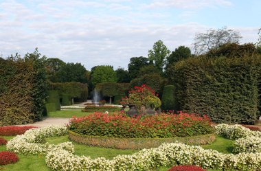 beautiful garden with flowers trees and fountain