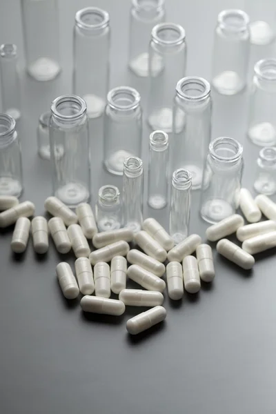 Cápsulas medicinais e recipientes de vidro — Fotografia de Stock