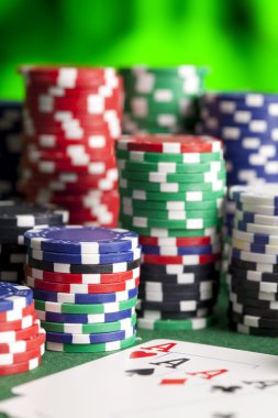 İskambil kartları ve yeşil masada poker fişleri