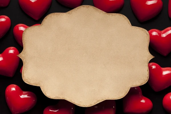 Паперовий ярлик на фоні червоних сердець — стокове фото