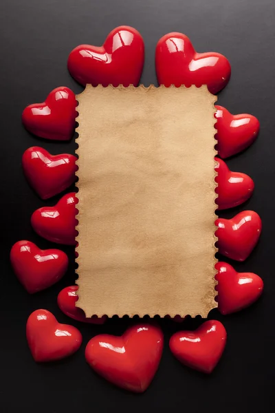 Порожня паперова етикетка та червоні серця на чорному тлі — стокове фото