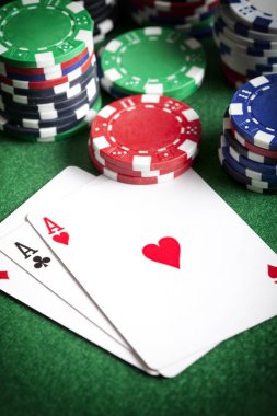 İskambil kartları ve yeşil masada poker fişleri