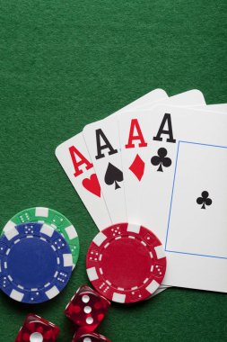 Playing cards, poker chips, and dices on green table clipart